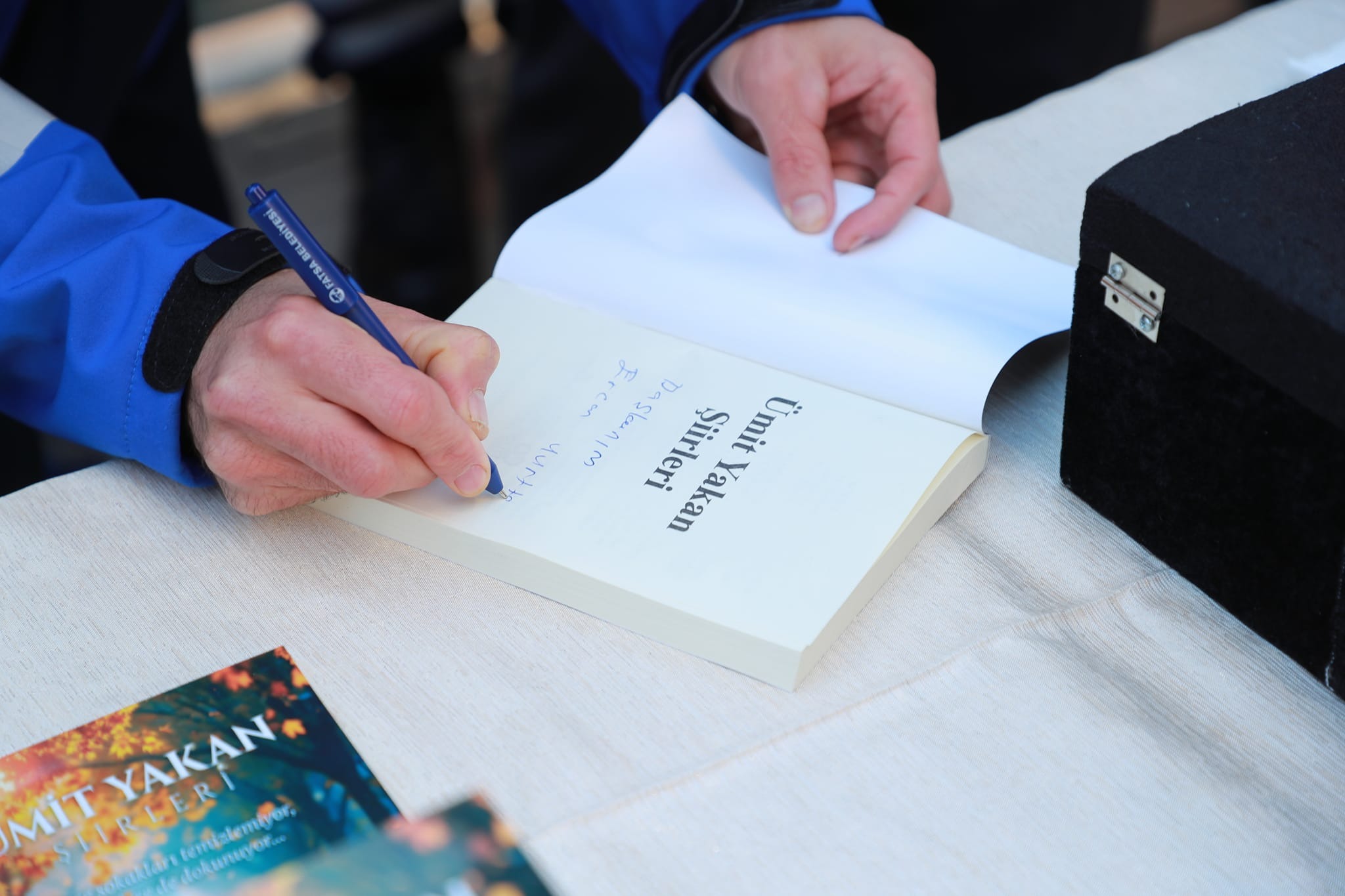 Fatsalı engelli yazar Ümit Yakan’ın şiir kitabı ile bir fotoğrafı.